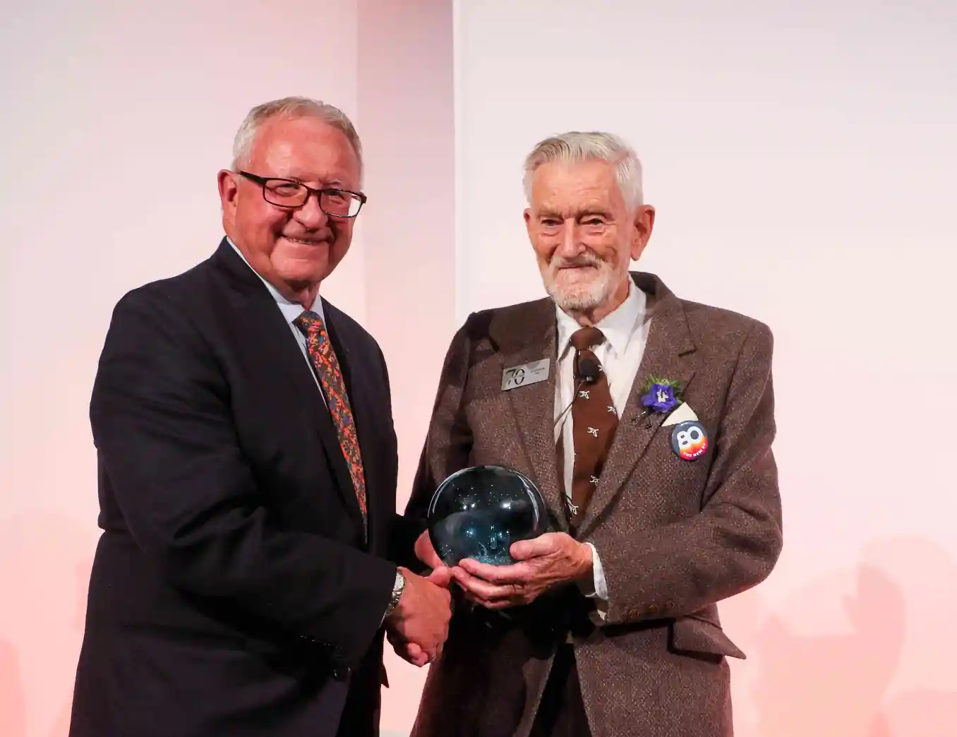 Kim McConnell gives a Top 7 Over 70 award to Gus Yaki.
